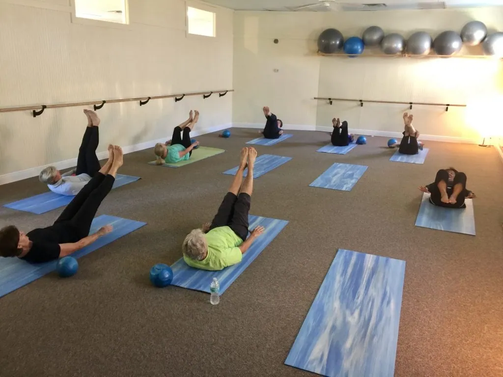 Students stretching on mats in the studio